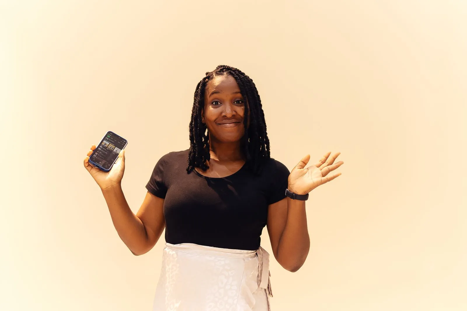 A smiling woman in Lagos holding a phone.